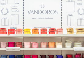 Colorful gift boxes arranged on shelves with a decorative background.