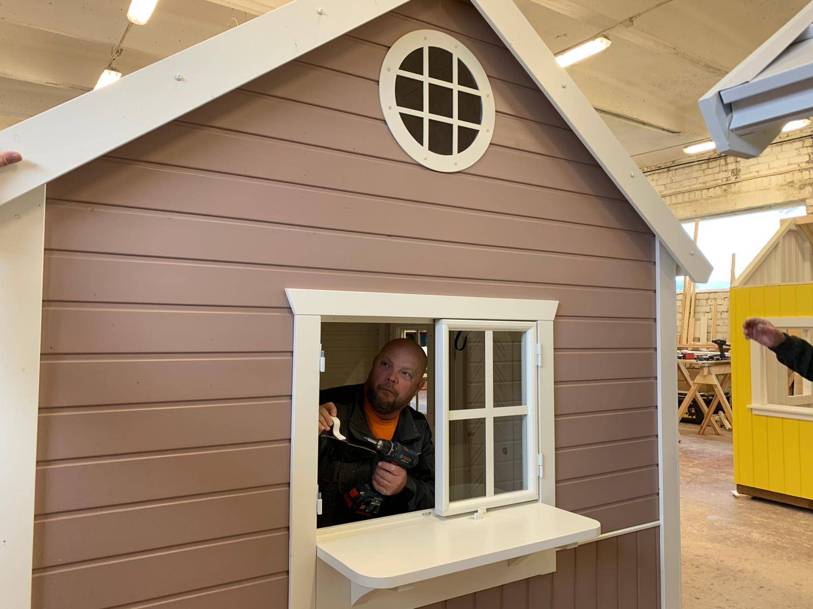 Closeup of a man making a custom playhouse shop window by WholeWoodPlayhouses