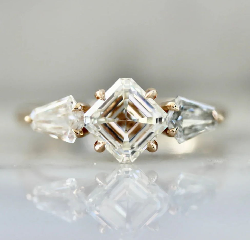 custom engagement ring with asscher cut diamond and shield cut side diamonds in 18k peach gold by gem breakfast