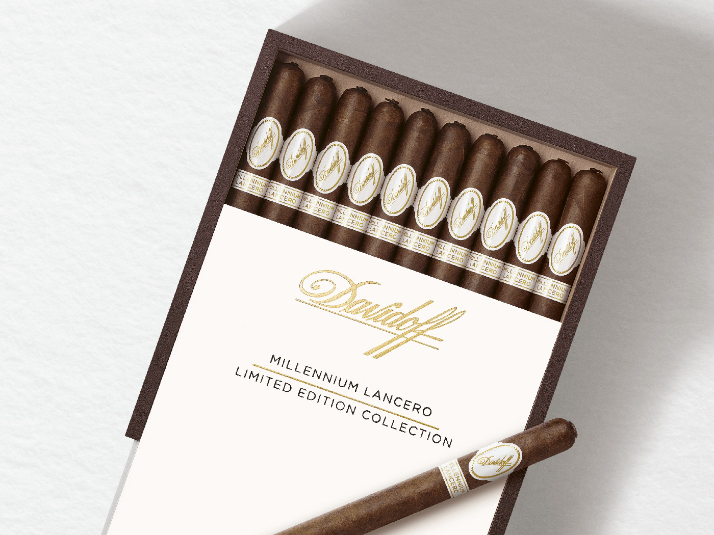 Geöffnete Kiste mit zehn Davidoff Millennium Lancero Zigarren drin und einer Zigarre obendrauf platziert. 