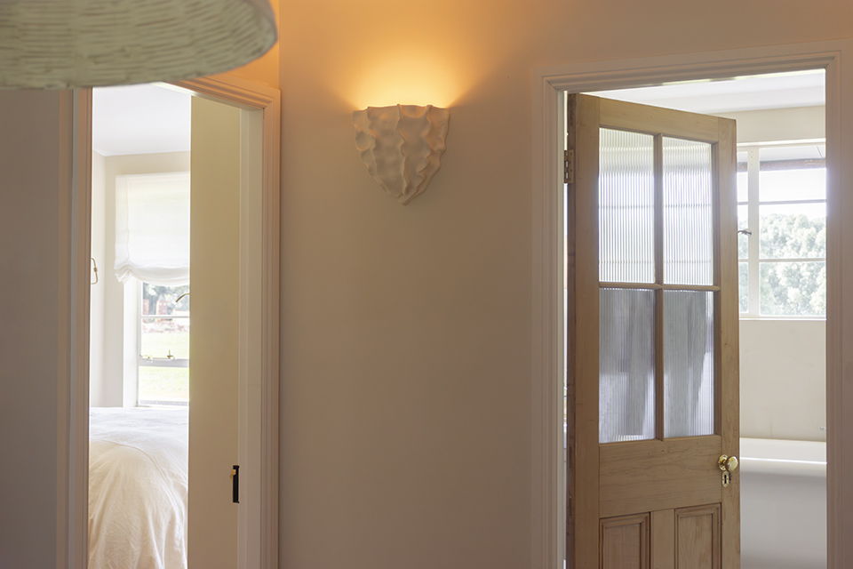 Wall sconce with organic sculptural shape and soft lighting
