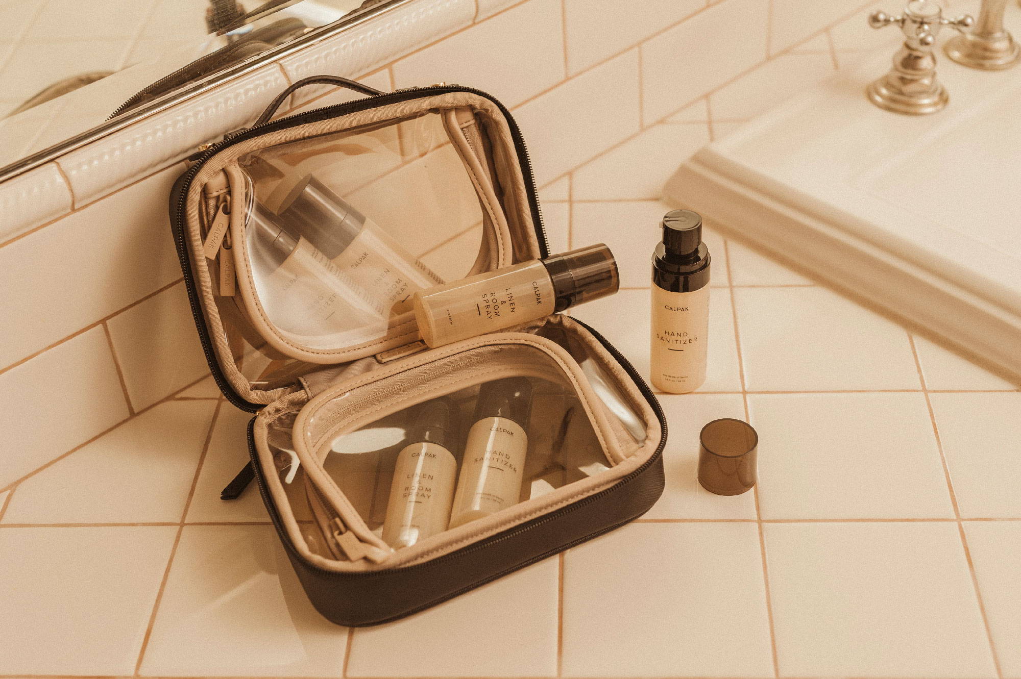 CALPAK Mini Clear Cosmetics Case in Eclipse, Everyday Hand Sanitizer, and Freshen Up Linen & Room Spray.