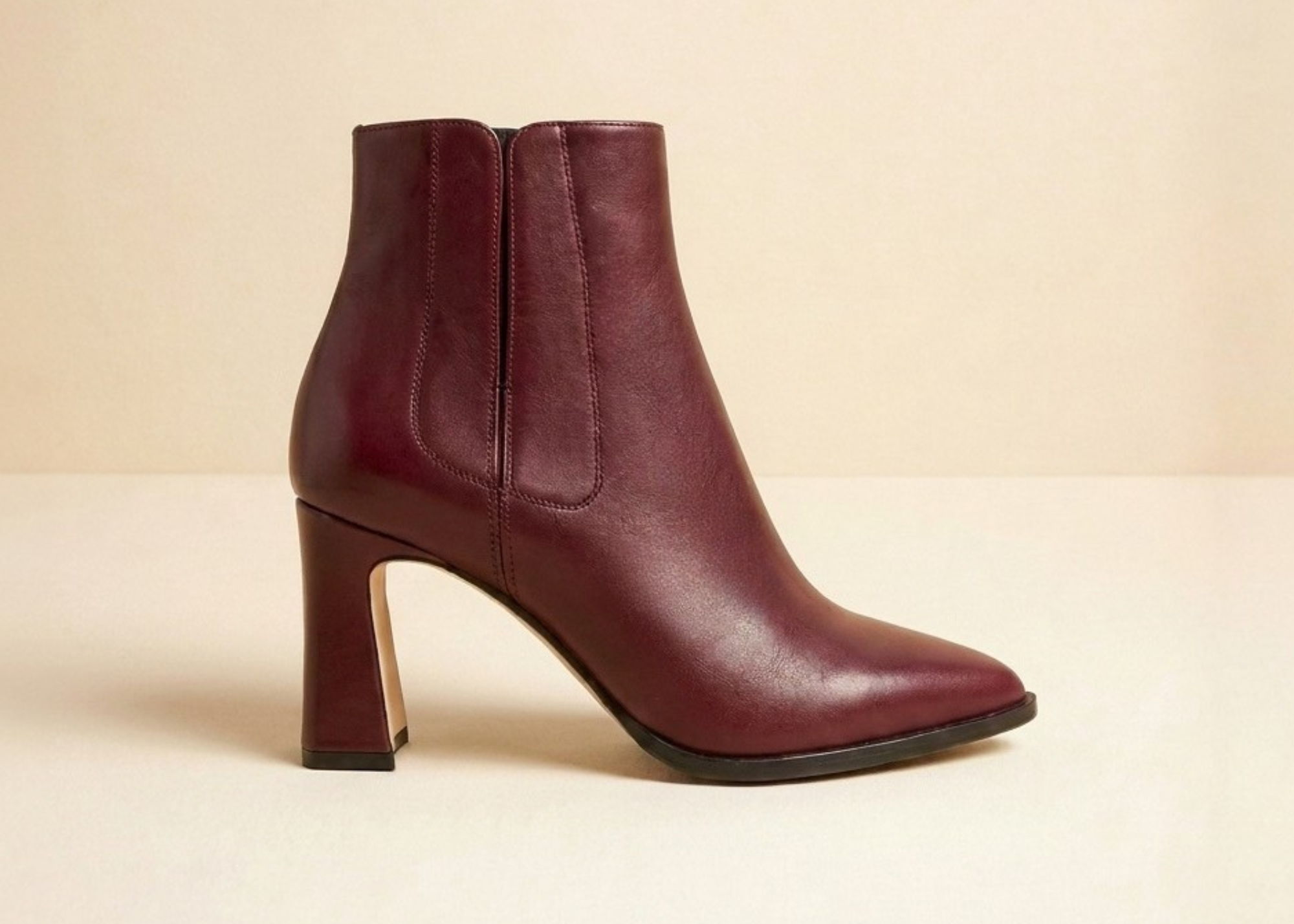 Maroon ankle boots with a high heel on a light background.