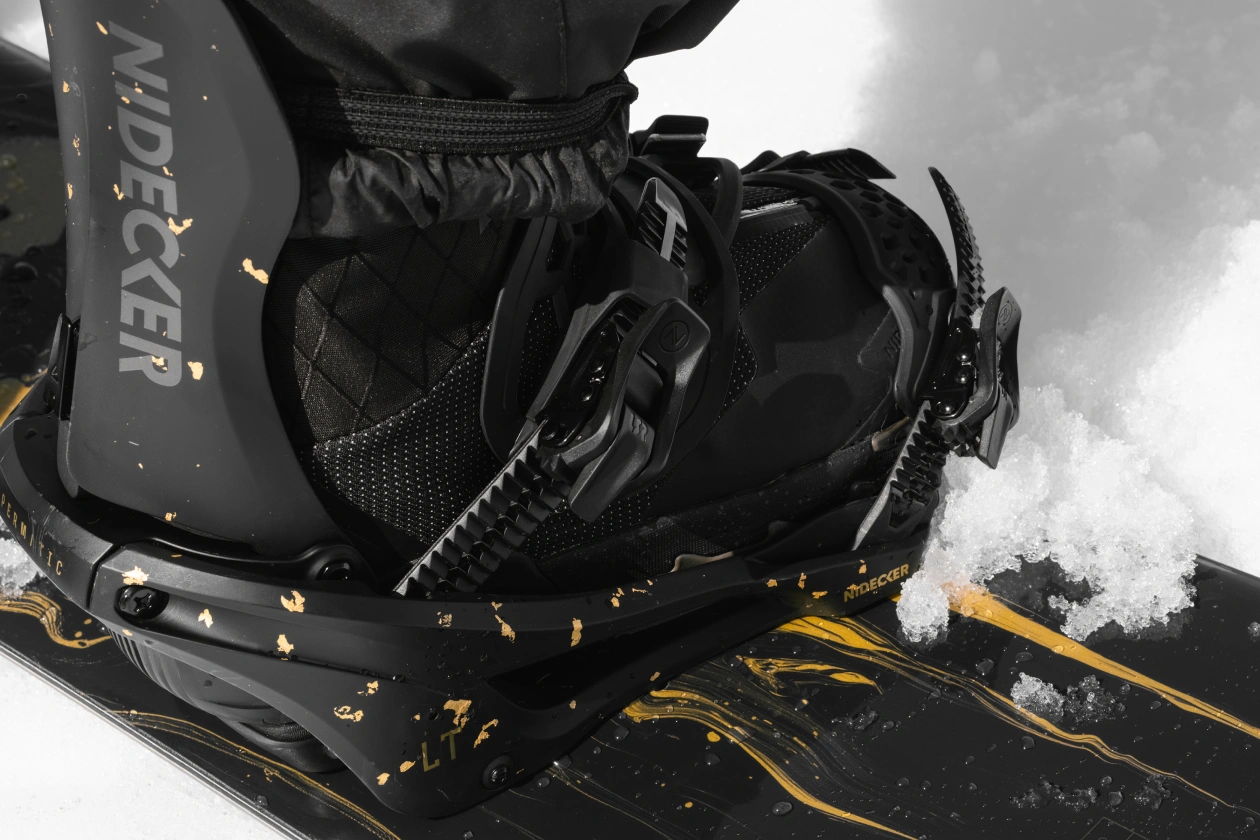 Close-up of a snowboard boot attached to a snowboard.