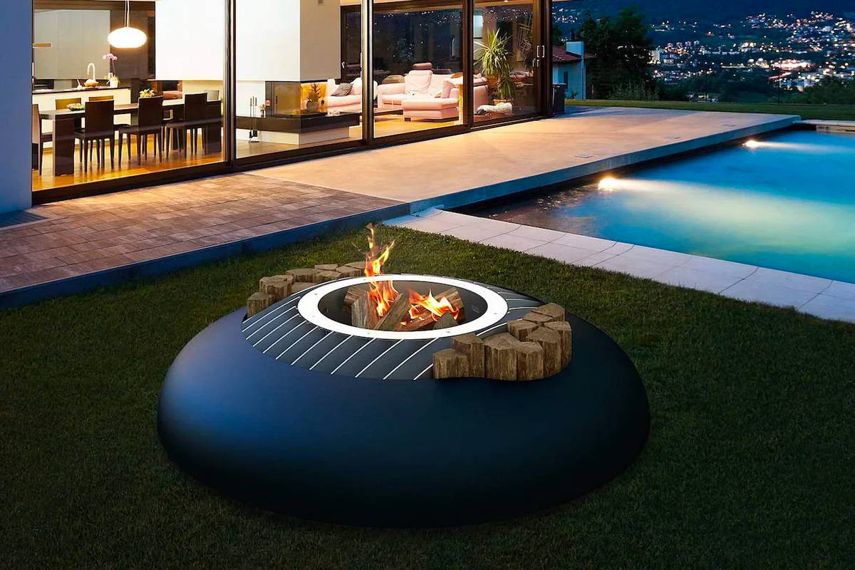 Modern fire pit by the pool with view of city lights.