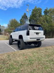 Lifted white and black Tahoe rear view thumbnail