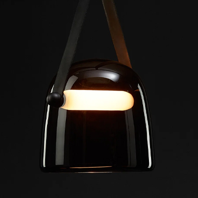 A modern black pendant lamp with a warm glow.
