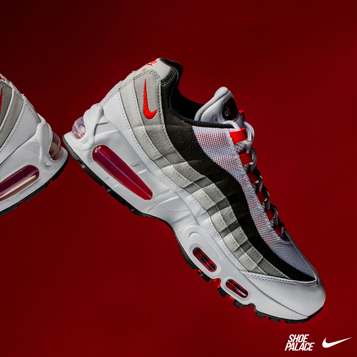 A pair of stylish sneakers on a red background.