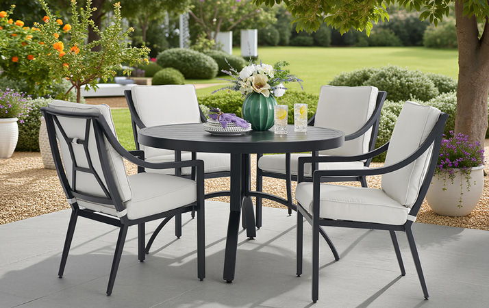 Outdoor dining set with chairs around a round table in a garden.