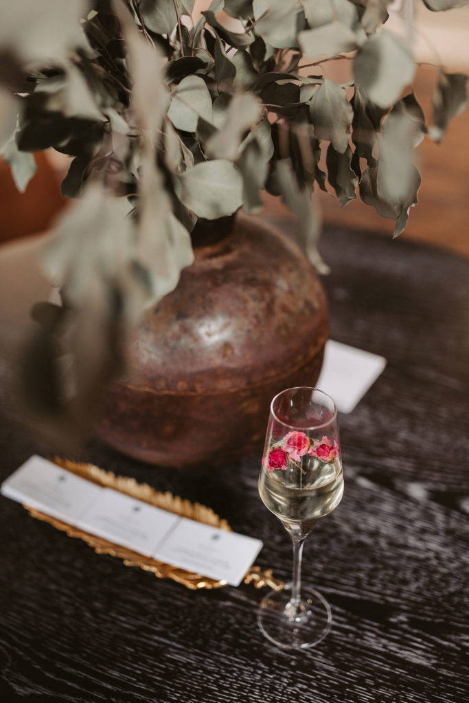 Copa de champán con flores en una mesa de madera negra