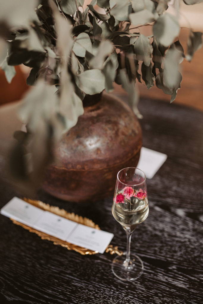 Verre à champagne avec des fleurs sur une table en bois noir