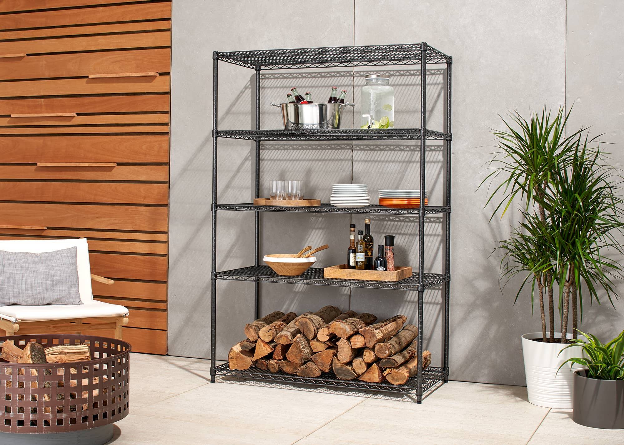 outdoor wire shelving rack on a patio filled with serving trays and fire wood