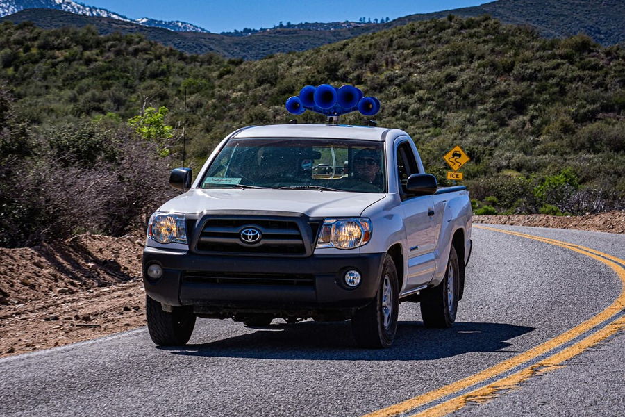 Front view Max's white 2009 Toyota Tacoma single cab on mountain road with blue Nathan AirChime P5 train horn mounted on roof HornBlasters featured install gallery photo 1