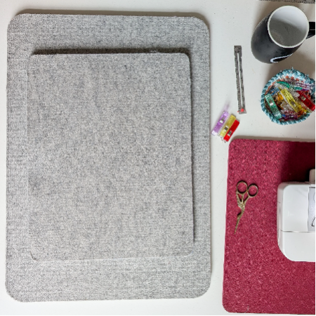 3 sizes of wool pressing mats stacked on a sewing table next to a sewing machine