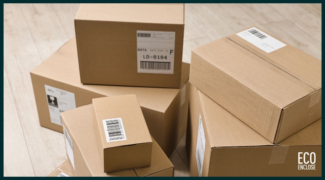 Several stacked cardboard boxes with shipping labels on a wooden surface.