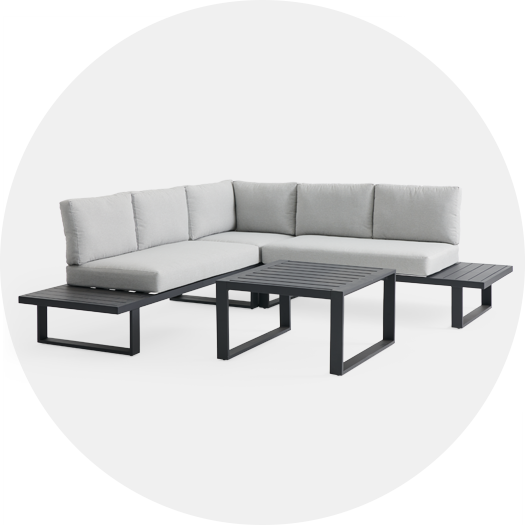 Modern sectional sofa with gray cushions and black frame, accompanied by two side tables.