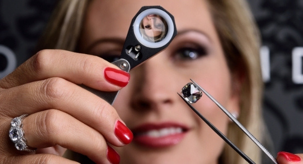 Inspecting a lab grown diamond under a magnifying glass