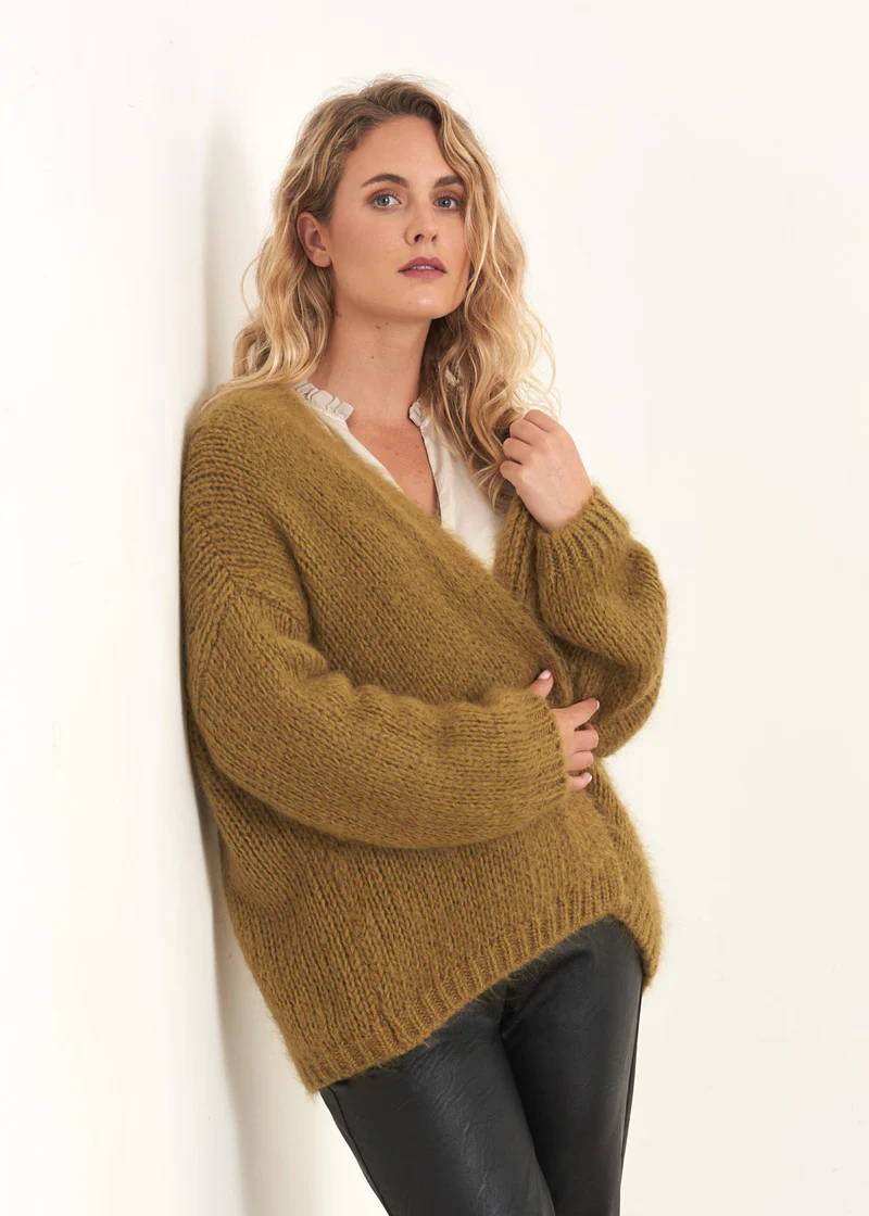 A model wearing a mohair blend, chunky oversized cardigan in olive green tones