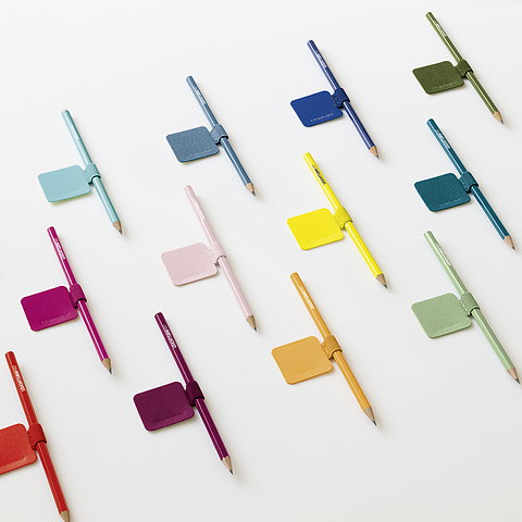 Colorful pencils arranged with matching sticky notes on a white background.