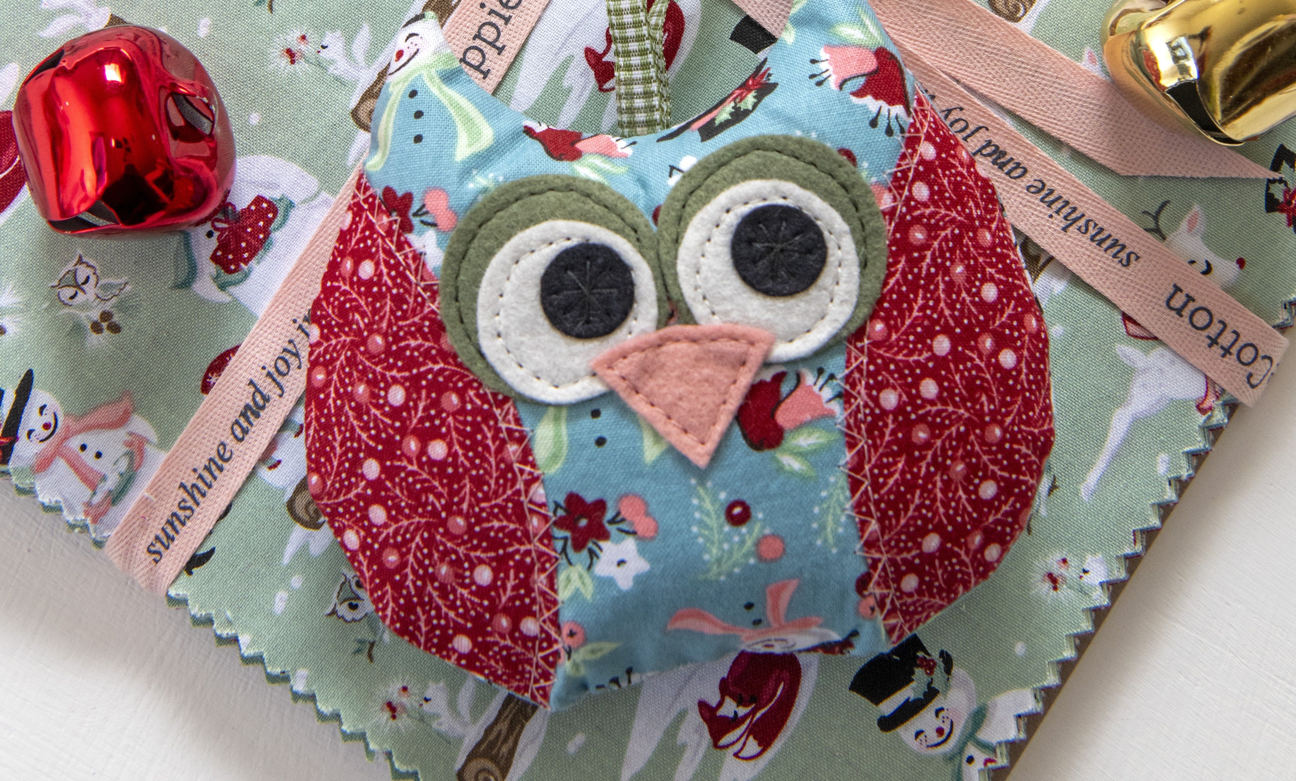Colorful owl plush toy on a festive background with bells.