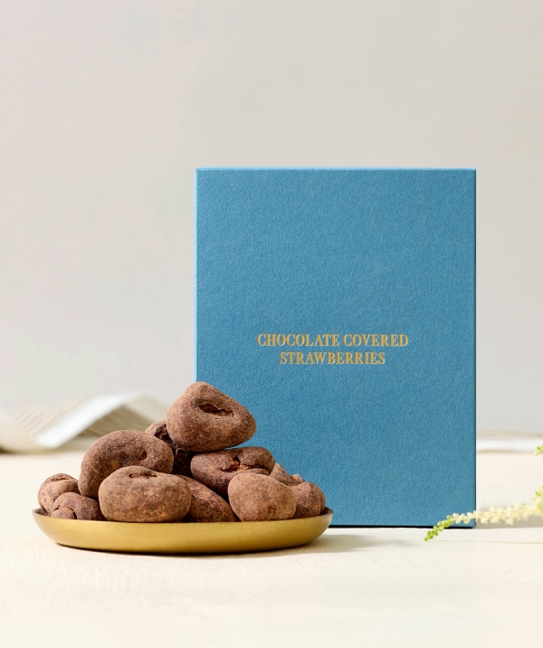 Chocolate treats on a plate beside a blue gift box.