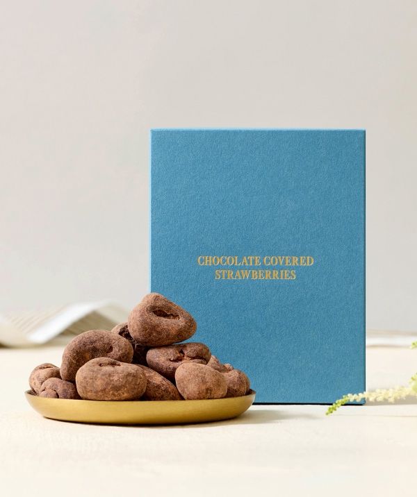 Chocolate treats on a plate beside a blue gift box.