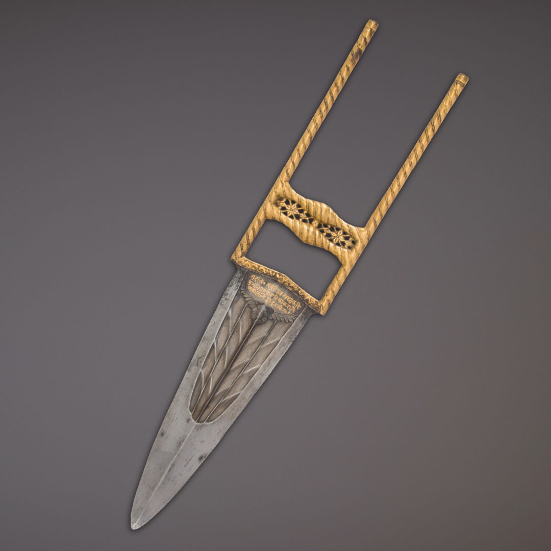 A decorative knife with a gold handle and a pointed blade.