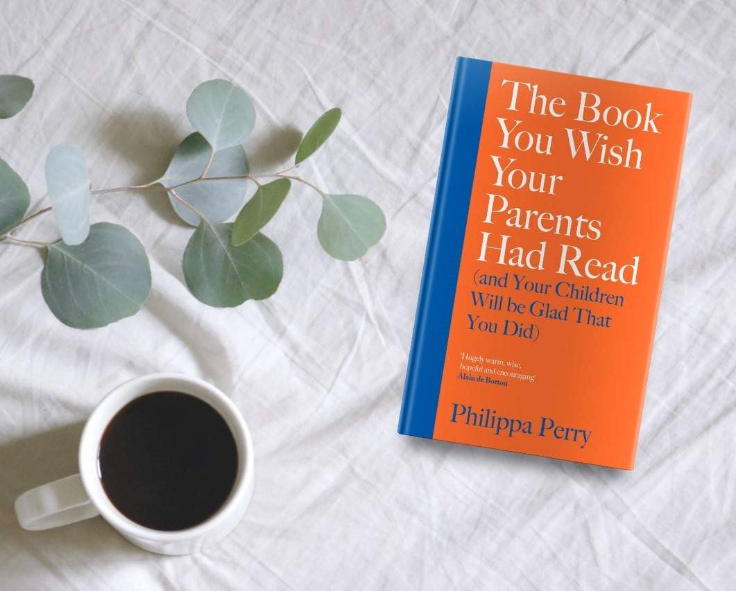 The Book You Wish Your Parents Had Read Laying On A Bed Sheet With A Cup of Coffee Next to it
