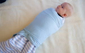 Baby in sleeping bag, with miracle blanket swaddle over the top