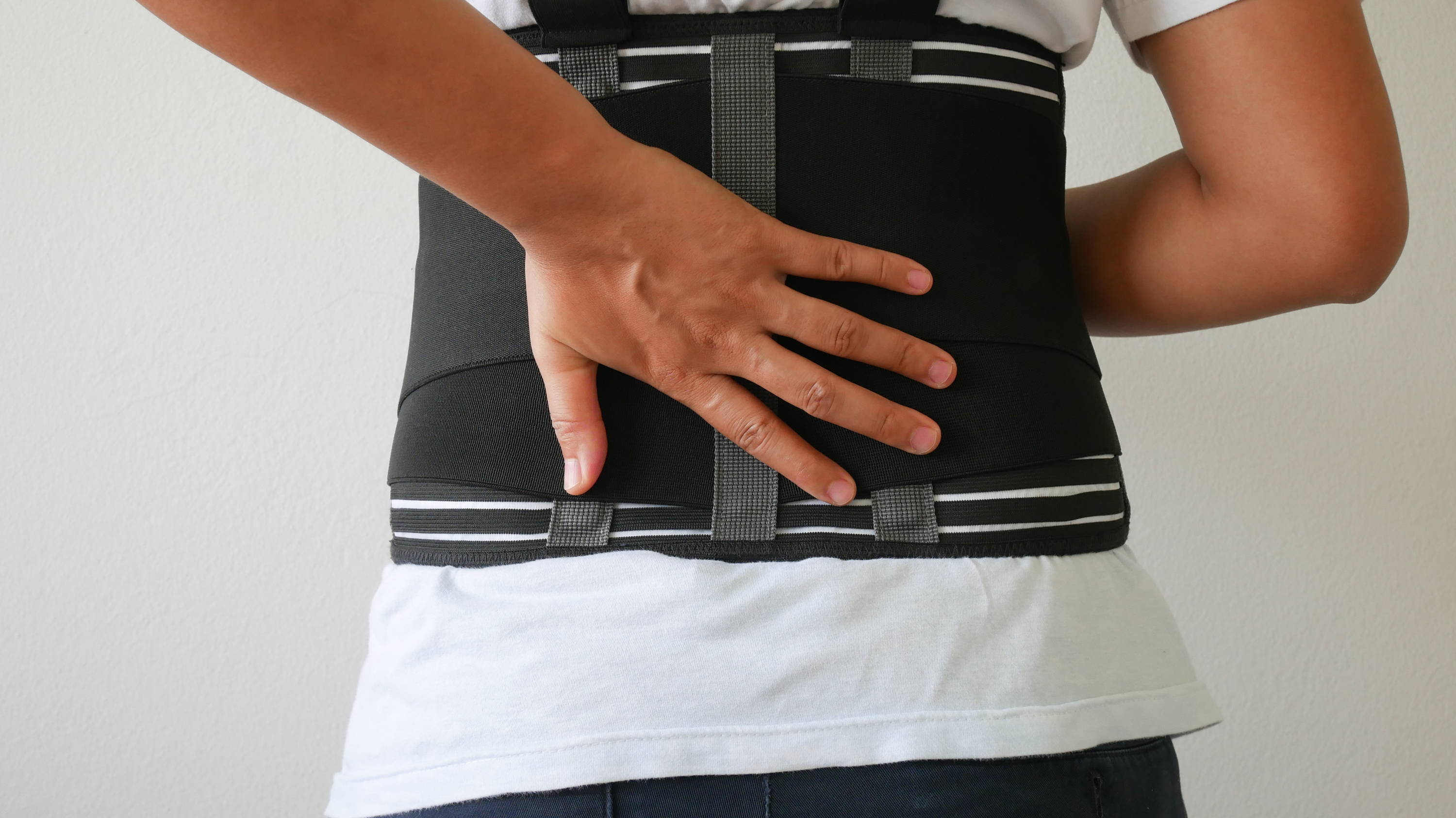Man wearing a back brace, but uncomfortable  from the snug fit