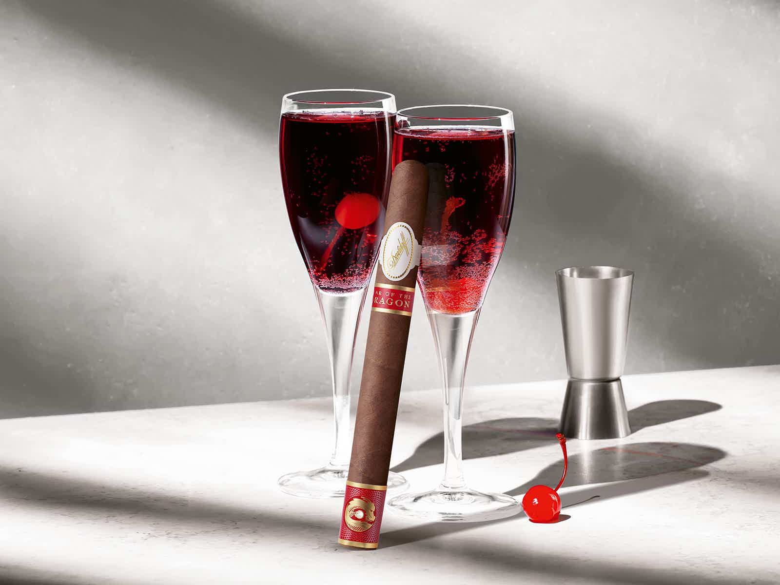 Die Davidoff Year of the Dragon Limited-Edition-Zigarre, die gegen eines von zwei mit Kir Royal gefüllten Gläsern besteht.