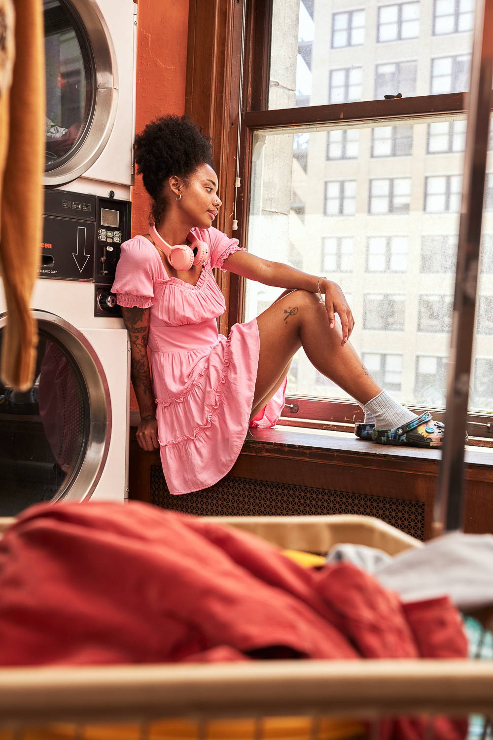 Trixxi Back to school embracing dorm life doing laundry and reading in a barbie pink tier dress.