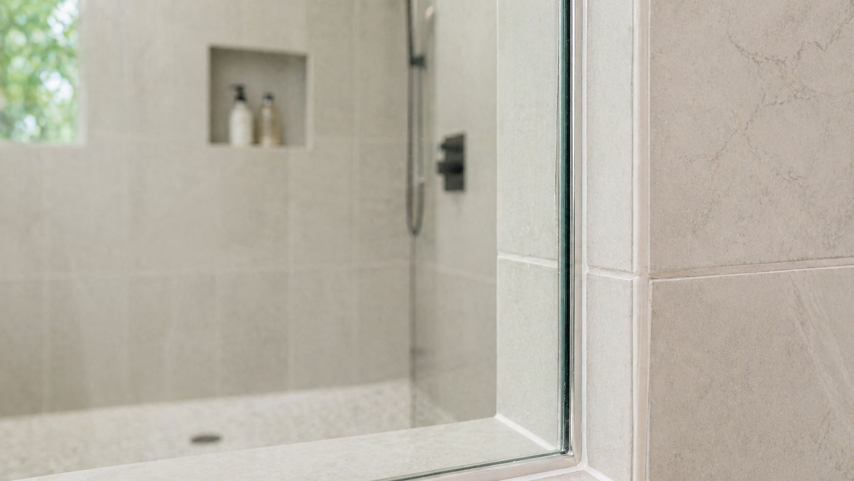 Modern bathroom with a glass shower and tiled walls.