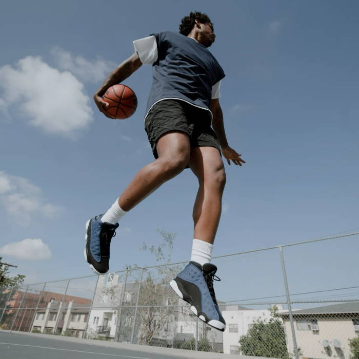 male playing basketball in aj13 brave blue