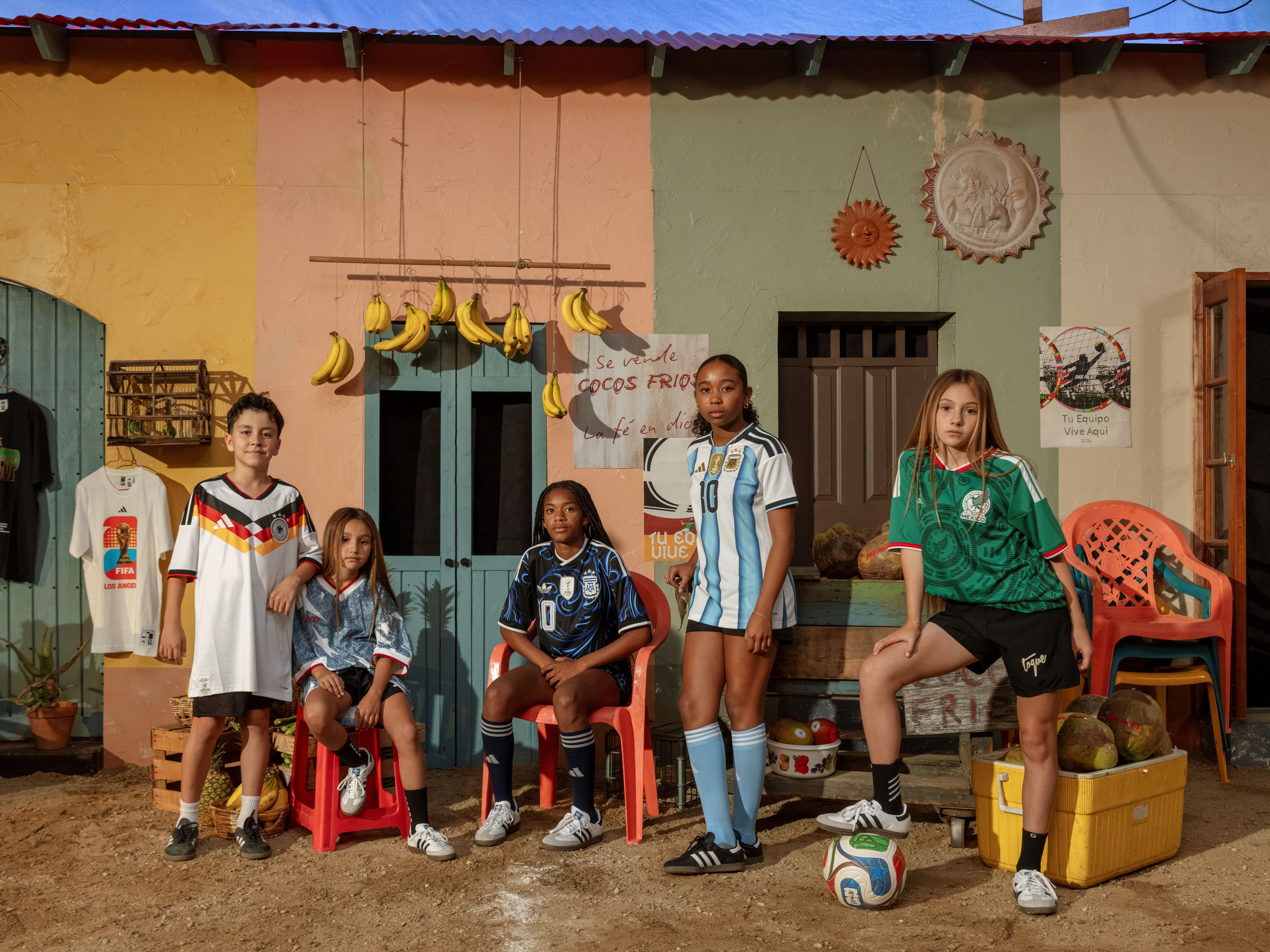 Children in soccer jerseys pose in a colorful setting.