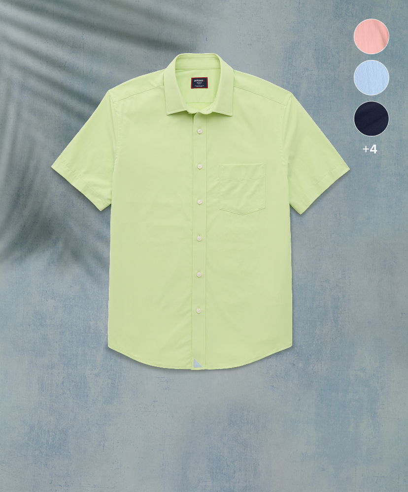 Light green short-sleeve shirt displayed against a textured background.