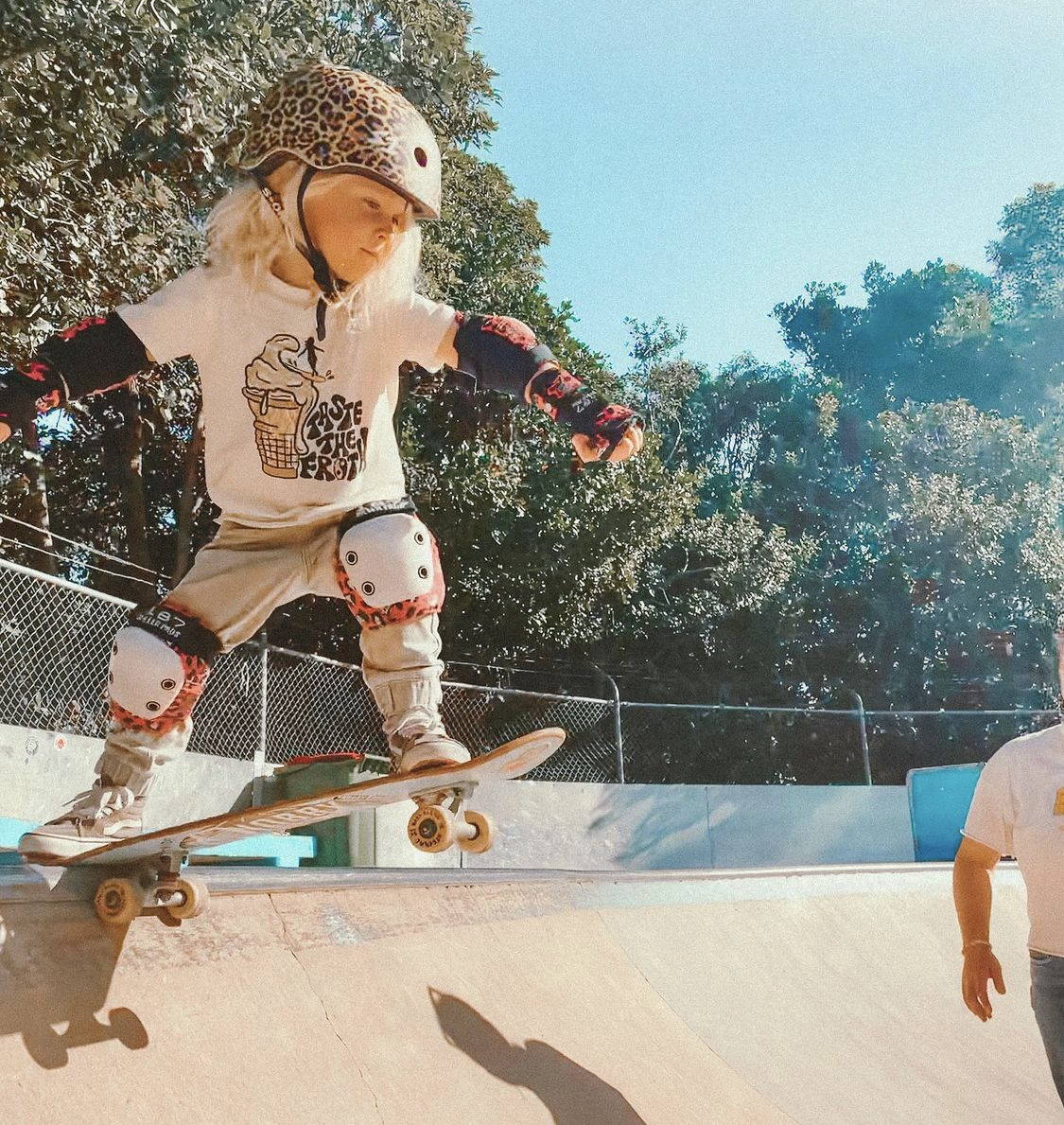 little kid dropping in a halfpipe on a skateboard. 