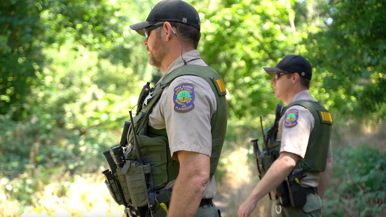 Two law enforcement officers in tactical gear outdoors.