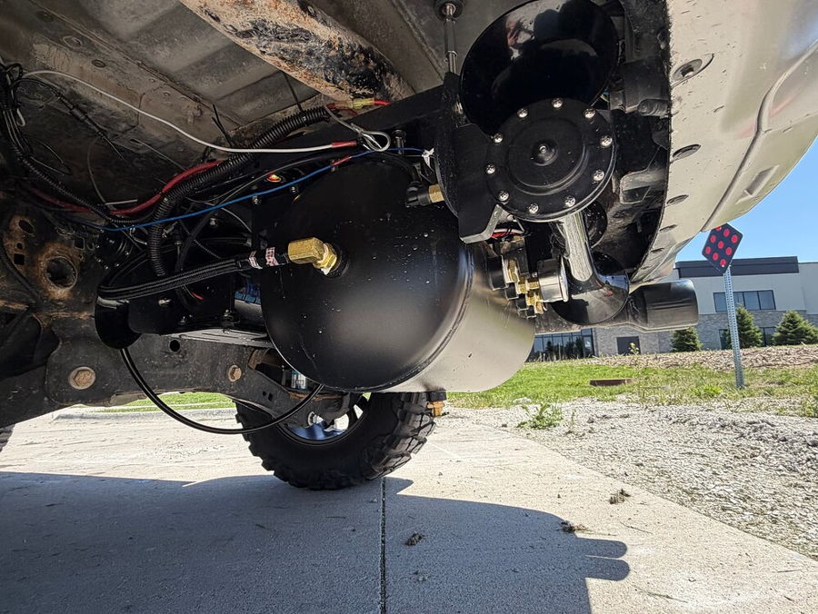 Under-rear view Stealth Spare Tire Delete black air tank train horns solenoid and wiring in spare tire well on Troy's 2018 Ford Expedition gallery photo 4