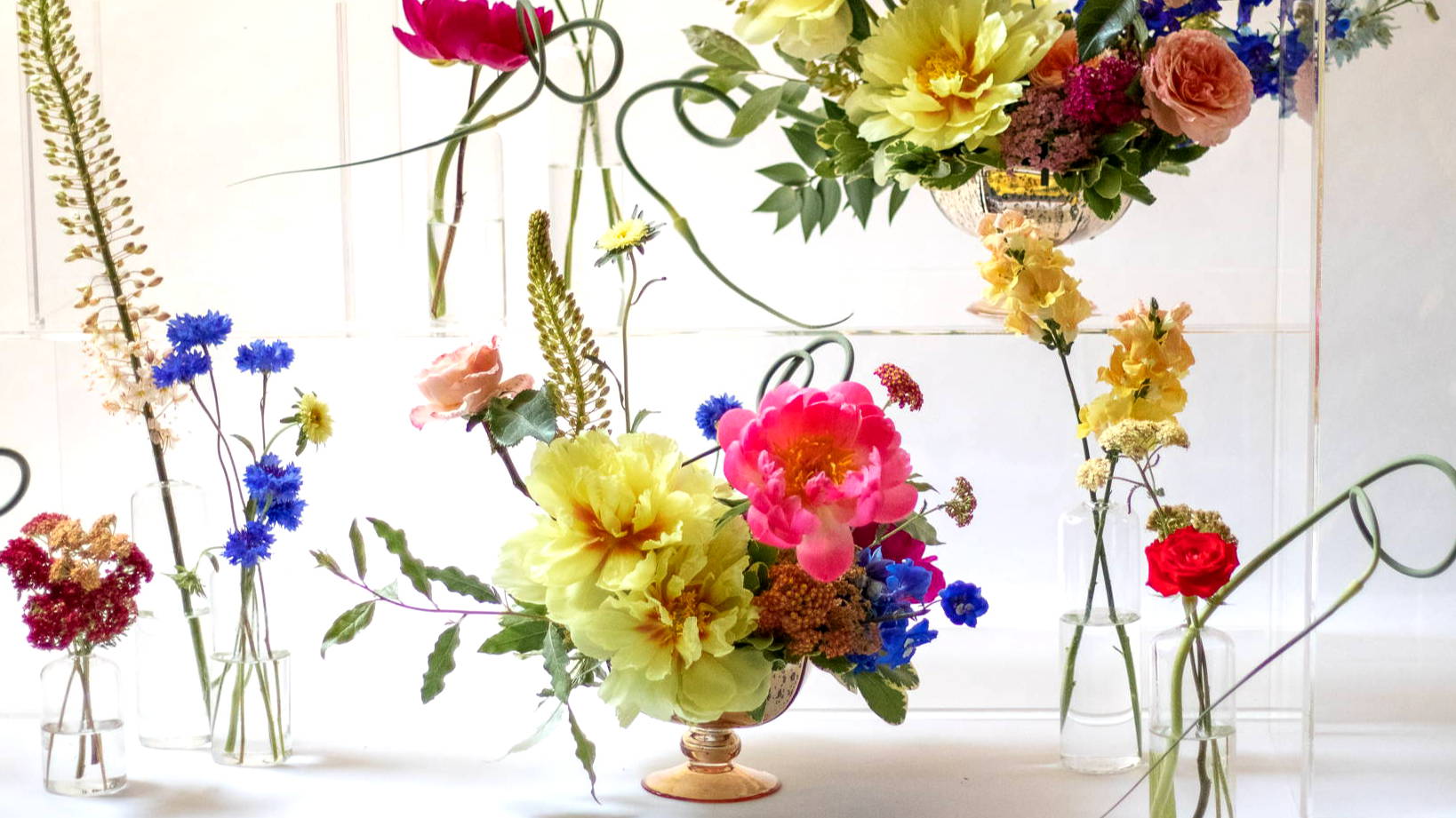 Assortment of bright yellow, pink and blue arrangements
