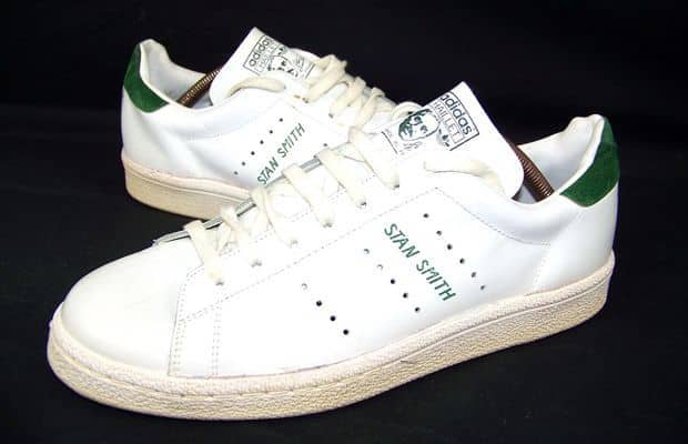 White sneakers with green accents on a black background.