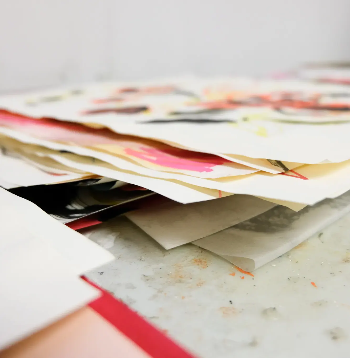 A stack of papers with colorful splashes of paint on them