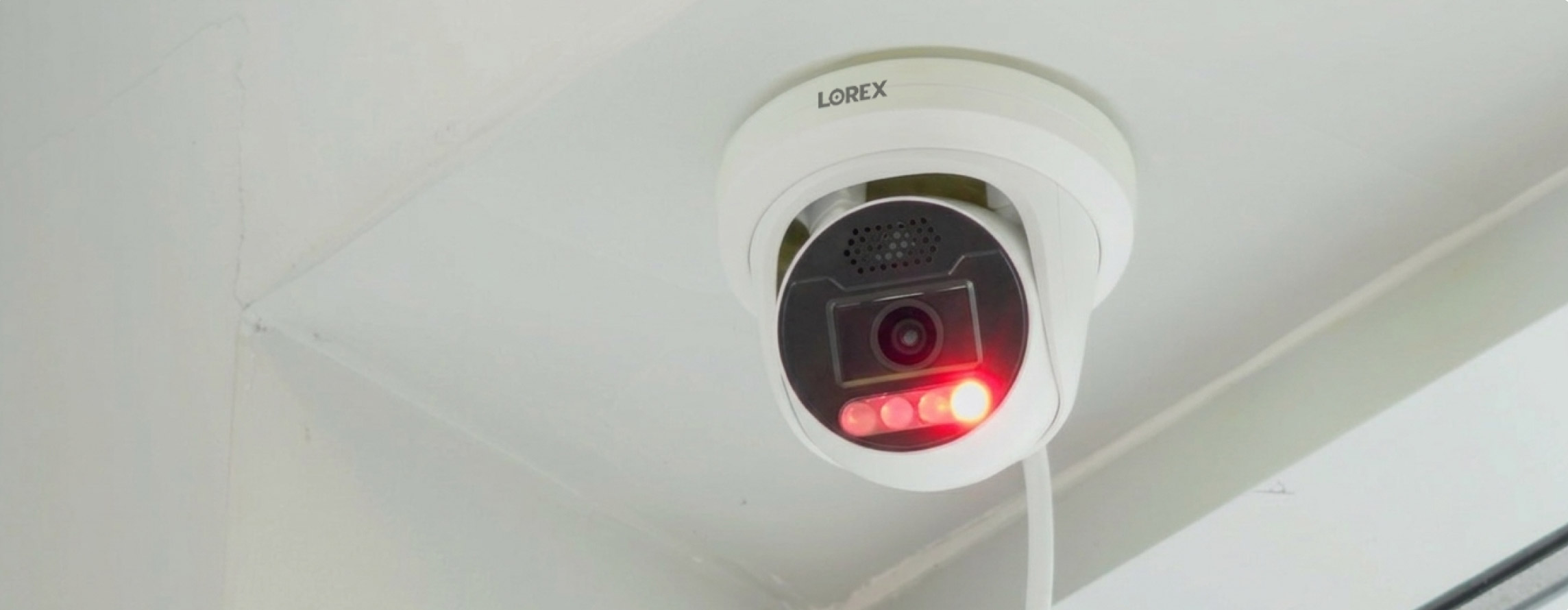 Close-up of an X5 series security camera mounted on a ceiling with red deterrence strobe light activated