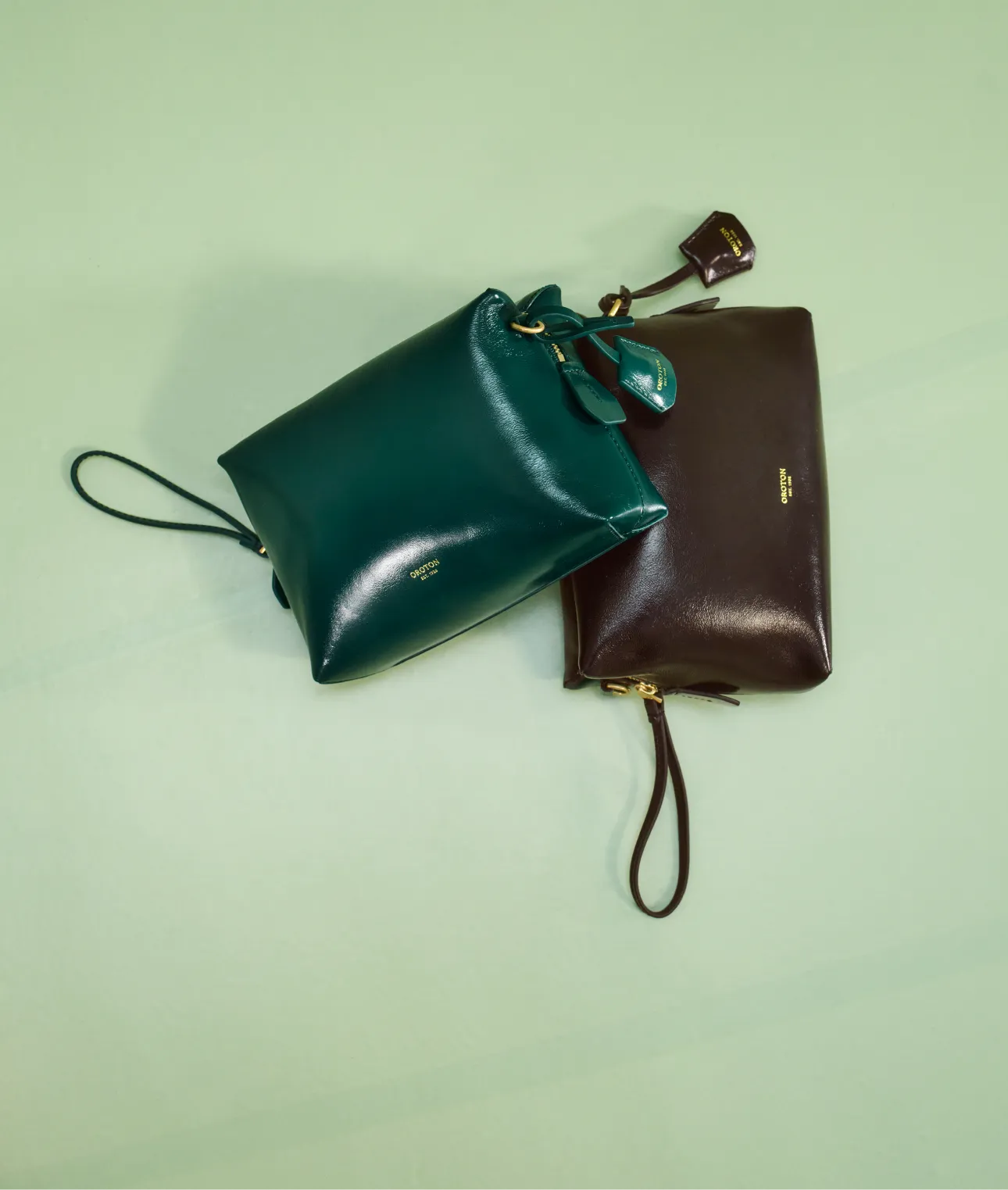 Two stylish bags, one green and one brown, on a light background.