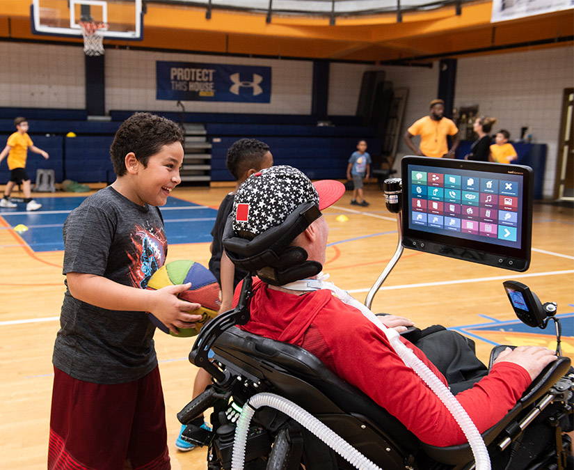 Man with ALS coaching kids basketball team with an eye gaze enabled Tobii Dynavox device