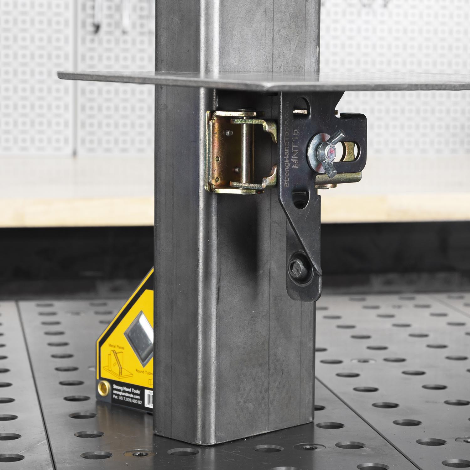 Metal structure with a clamp and measuring tool on a work surface.