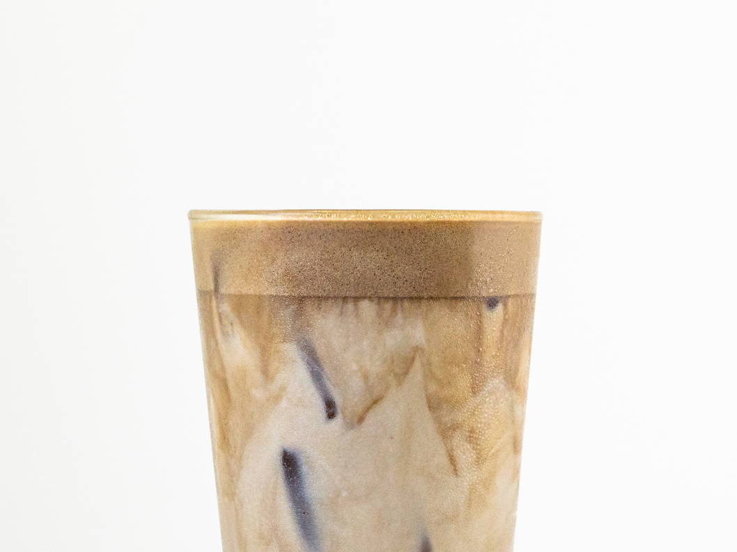 A tall cup with a marbled Roasted Matcha Latte