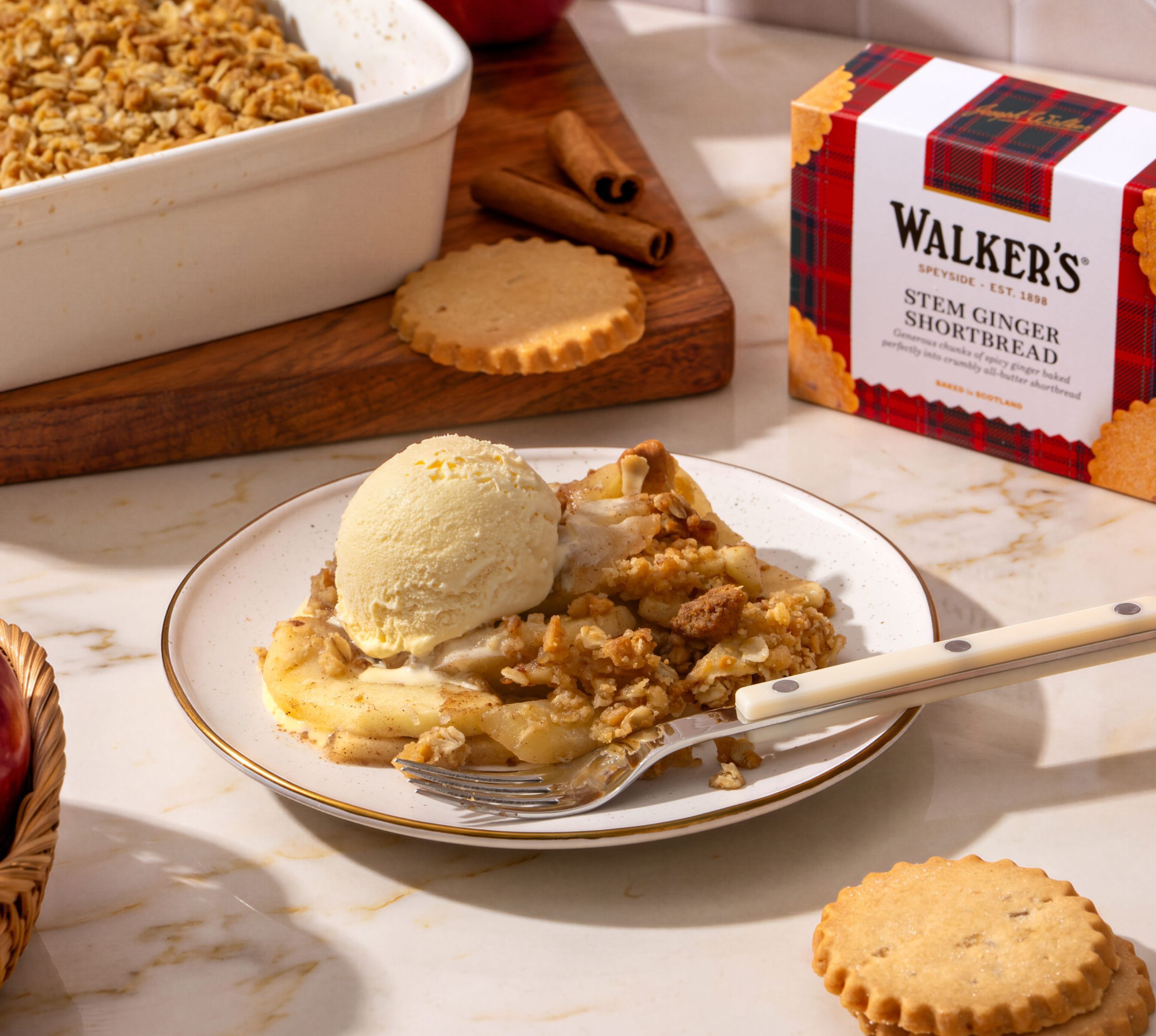 Dessert with ice cream, cookies, and a baked dish in the background.