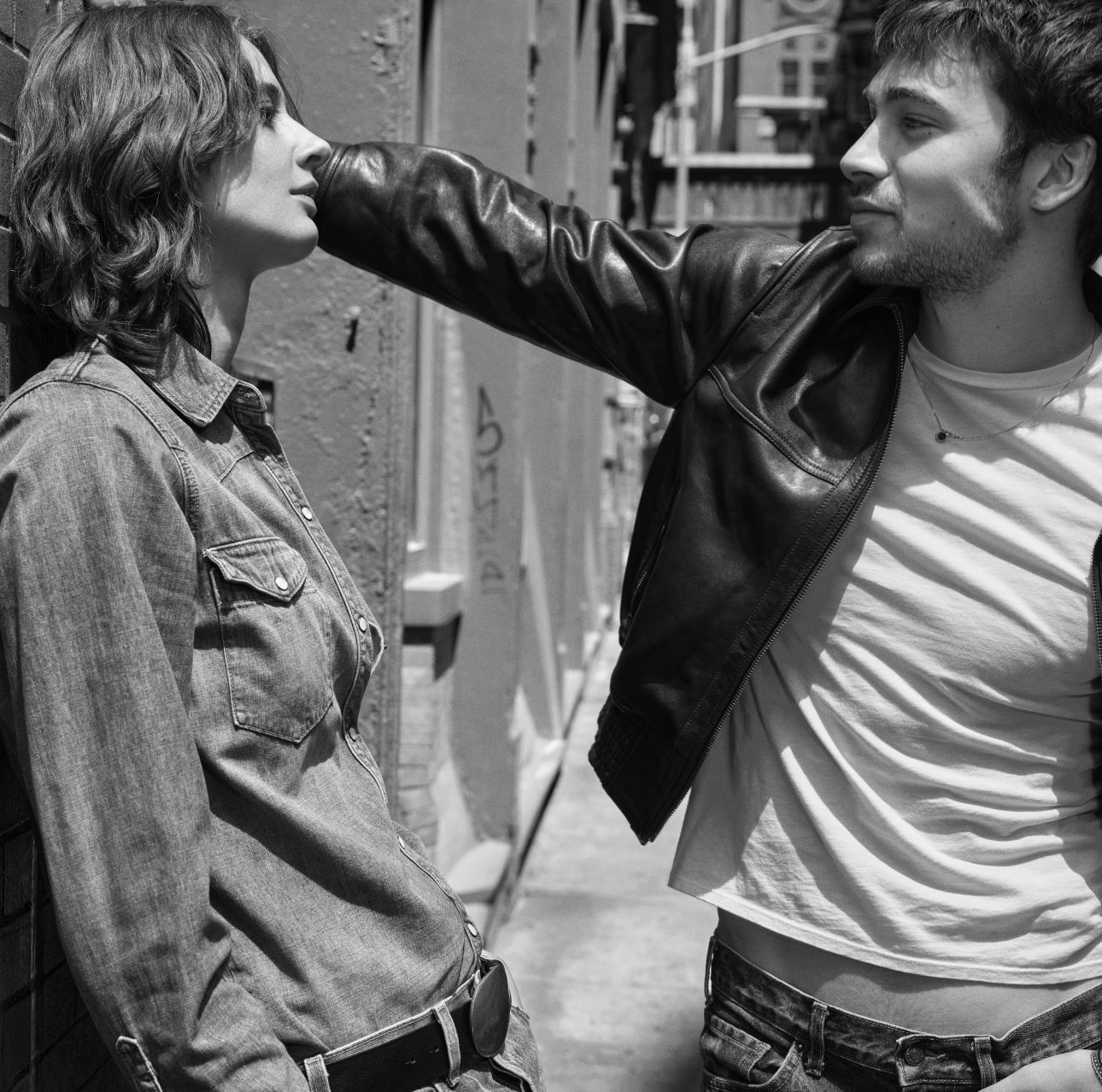 A black and white photo of a couple in an alleyway.