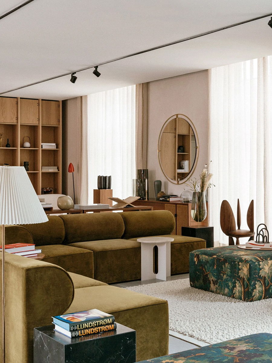 Modern living room with a brown Audo Sofa and wooden shelves.